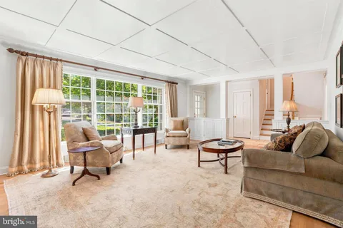 a living room with furniture and floor to ceiling windows