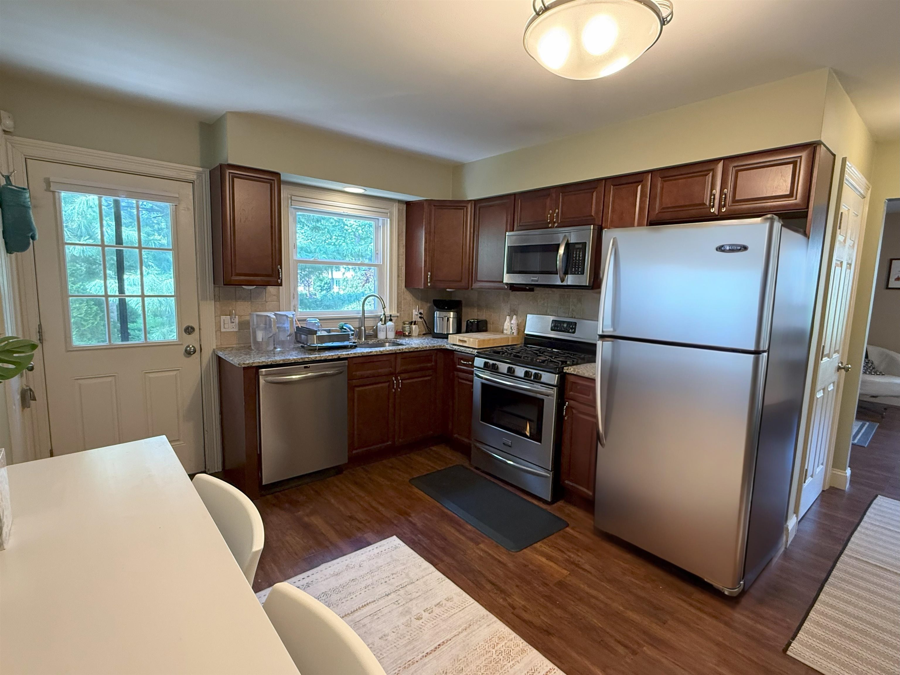 45 Garfield Place, Unit 1 (1ST FLOOR) Ridgewood, NJ 07450 - Photo 6 of 33 a kitchen with stainless steel appliances kitchen island granite countertop a refrigerator a sink dishwasher a stove with wooden cabinets and floor