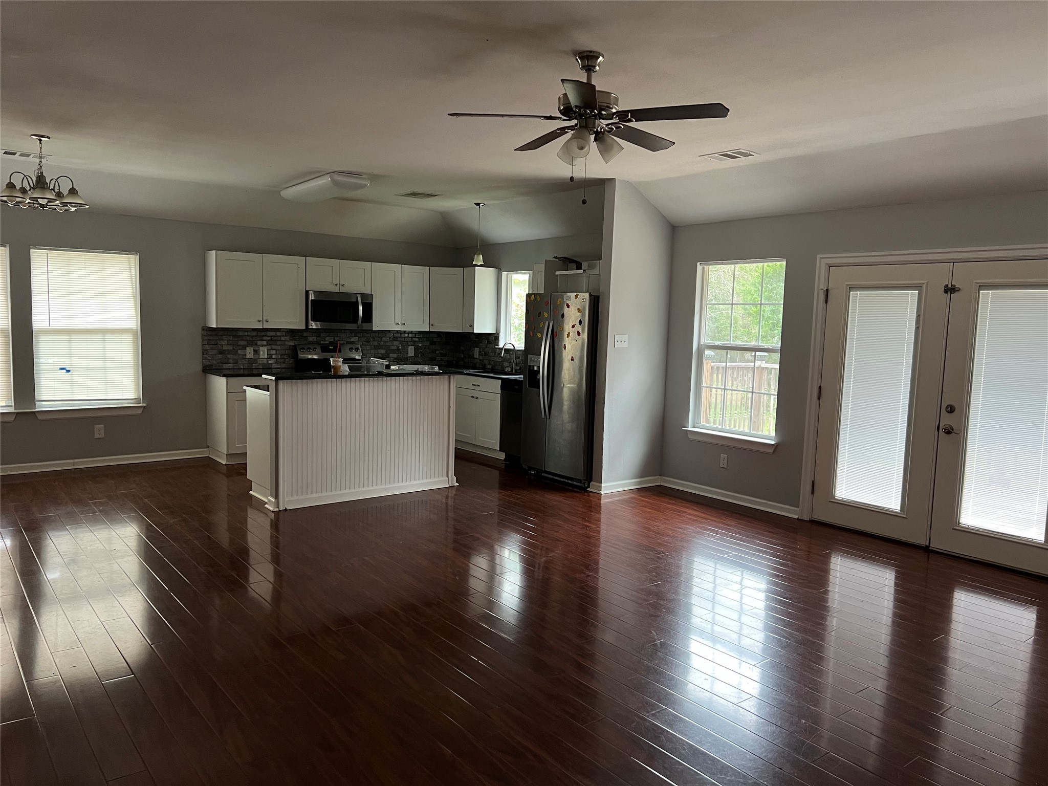 239 Old Firetower Road Bastrop, TX 78602 - Photo 37 of 39 Kitchen featuring dark countertops, white cabinets, french doors, open floor plan, and black appliances