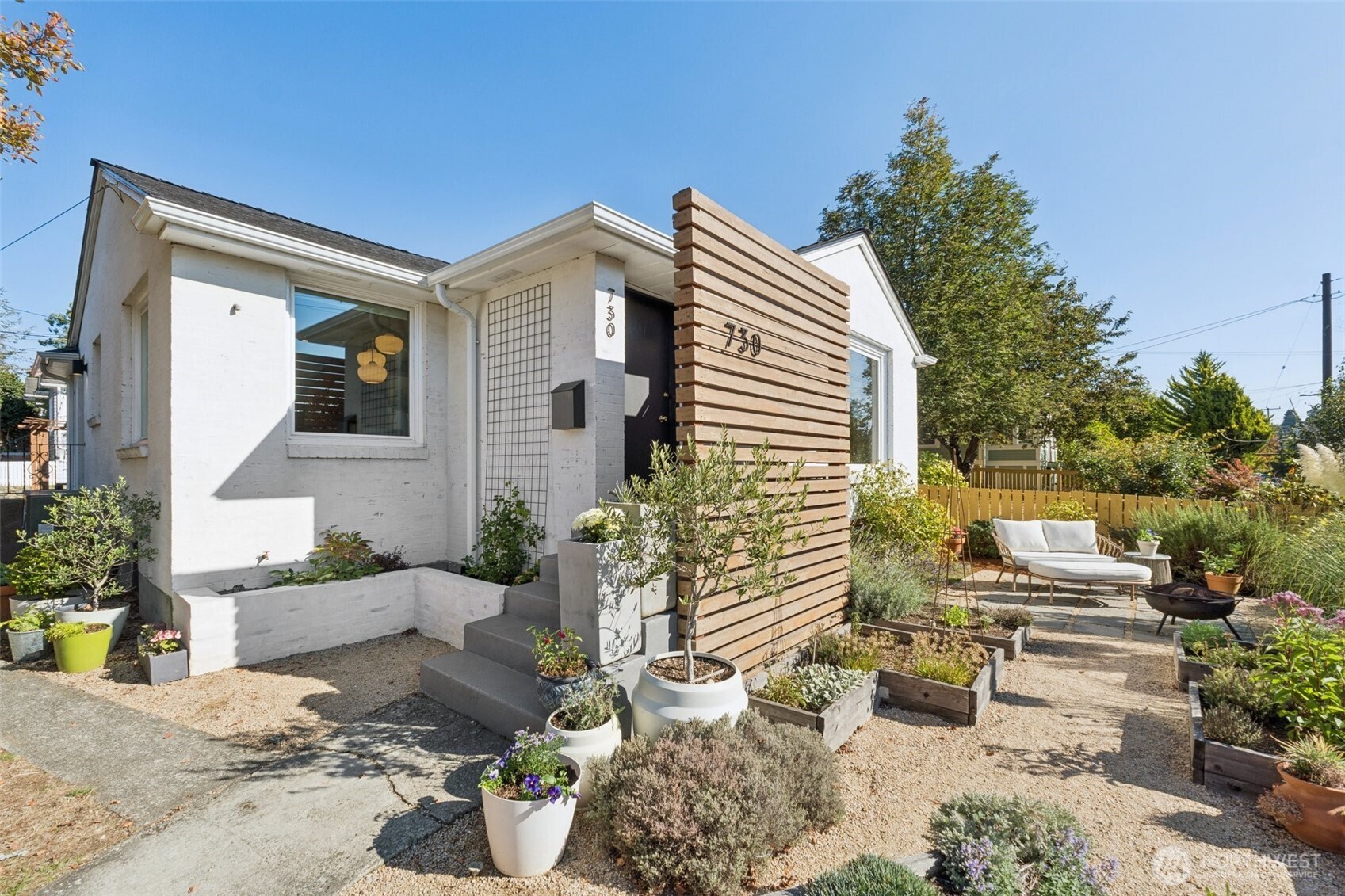 730 Northwest 73rd Street Seattle, WA 98117 - Photo 1 of 39 a view of a patio with couches table and chairs and potted plants