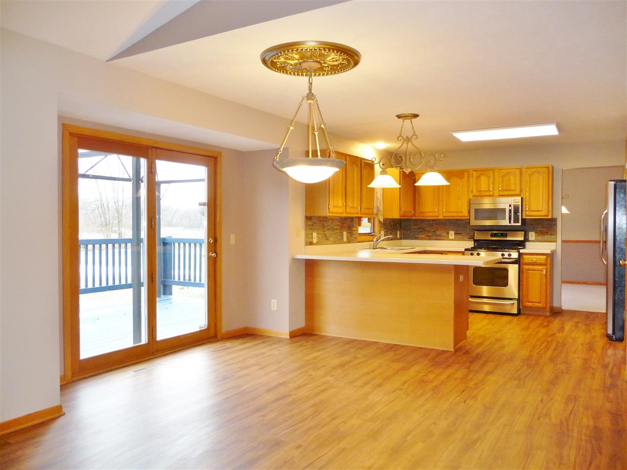 4349 Waltham Road Roscoe, IL 61073 - Photo 8 of 27 a kitchen with stainless steel appliances granite countertop a stove and wooden floor