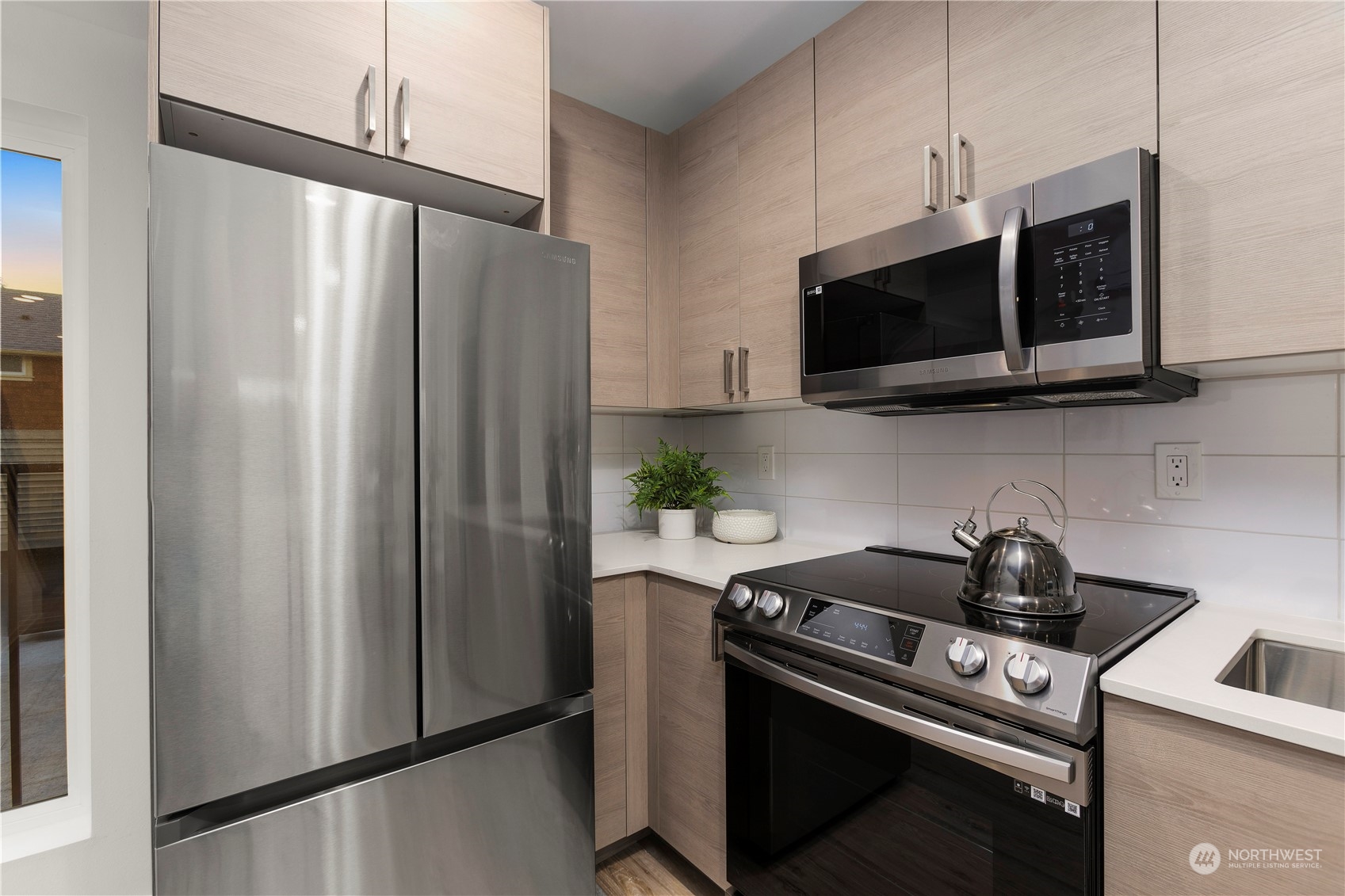 3102 South Walden Street Seattle, WA 98144 - Photo 10 of 35 a kitchen with stainless steel appliances a microwave a refrigerator a stove and white cabinets