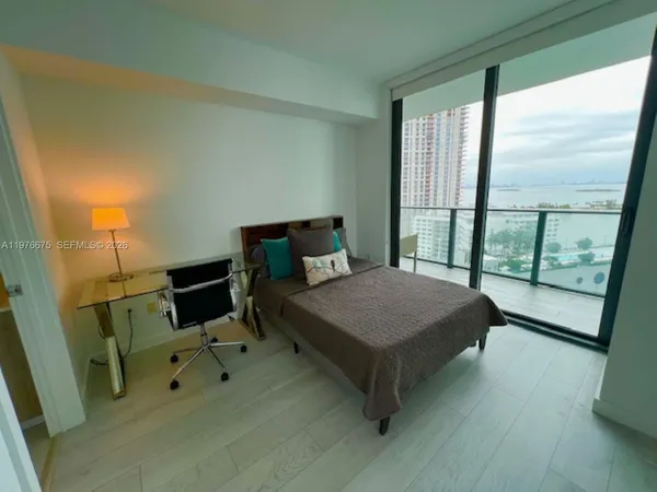 a bedroom with a bed and large window
