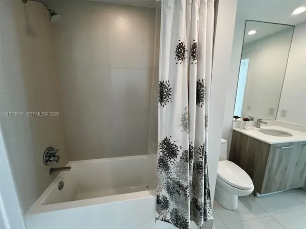 a bathroom with a sink a toilet a mirror a vanity and bathtub