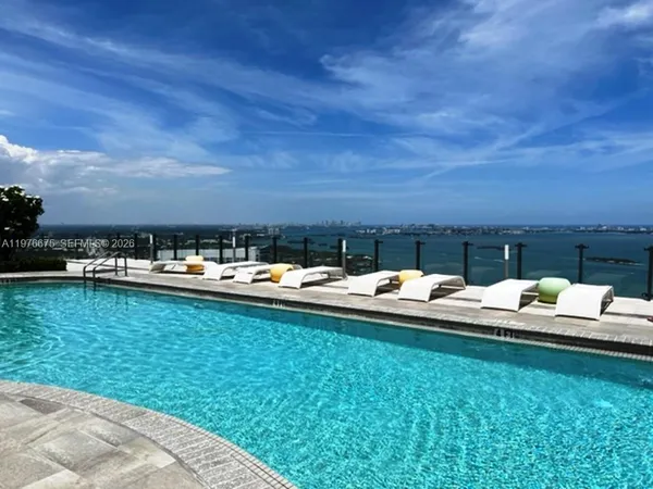 a view of swimming pool with outdoor seating and yard in back