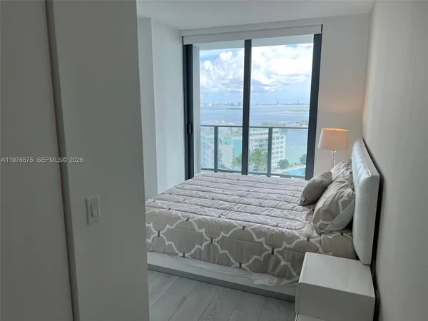 a bed sitting in a bedroom next to a window