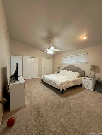 a spacious bedroom with a bed and a chandelier