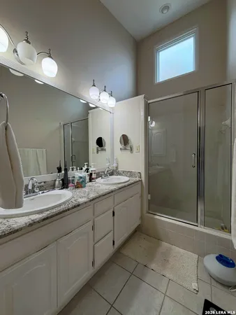 a bathroom with a granite countertop sink mirror and shower