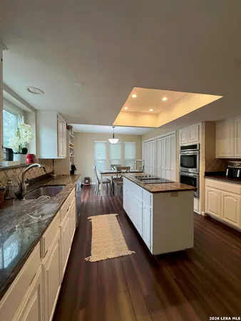 a large kitchen with stainless steel appliances kitchen island granite countertop a stove a sink and a refrigerator