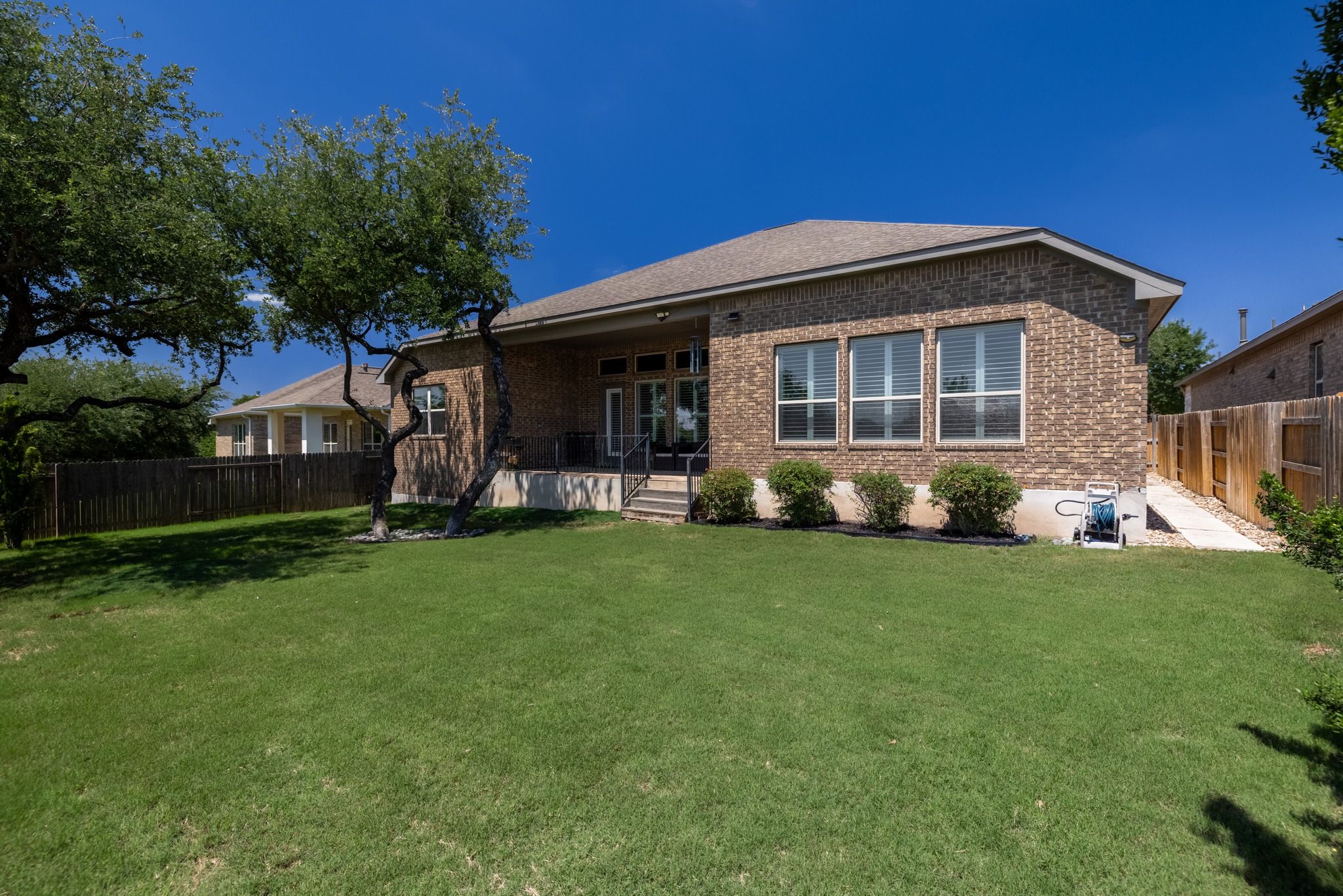 4105 Haight Street Round Rock, TX 78681 - Photo 35 of 40 Expansive backyard featuring a manicured lawn, established trees, and a brick exterior