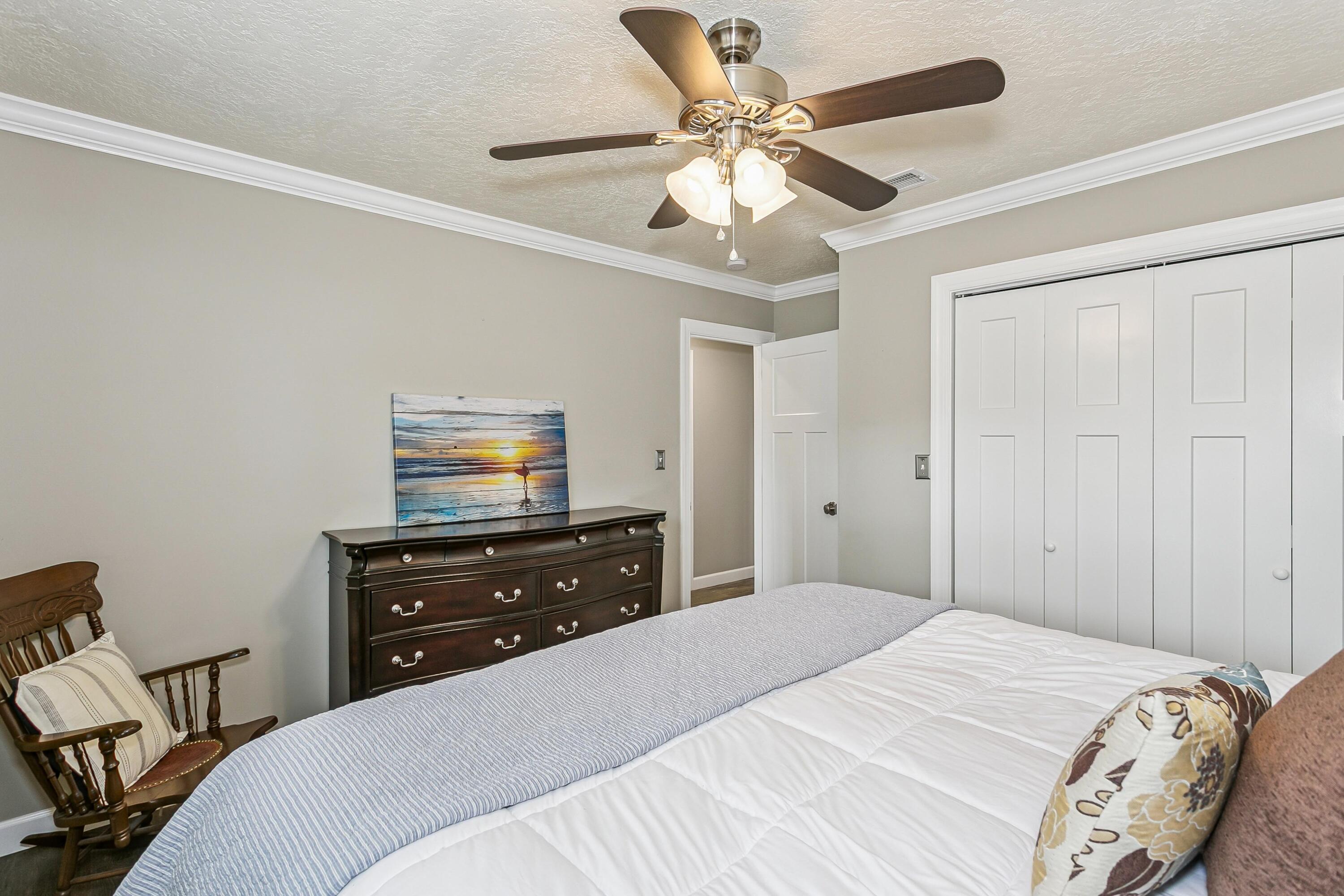 76 Country Club Road Shalimar, FL 32579 - Photo 24 of 47 a bedroom with a bed and a chandelier