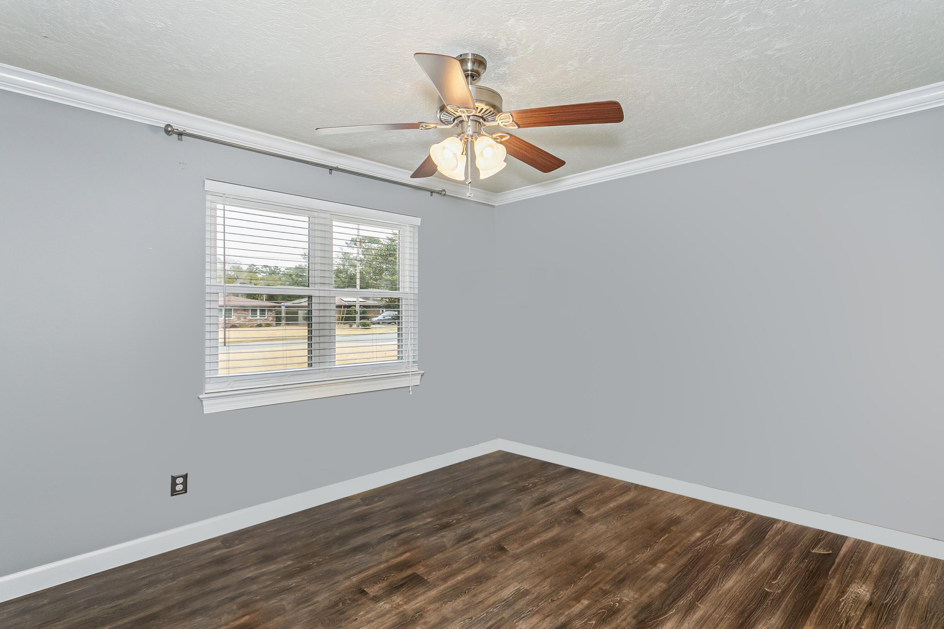 76 Country Club Road Shalimar, FL 32579 - Photo 25 of 47 an empty room with wooden floor fan and windows