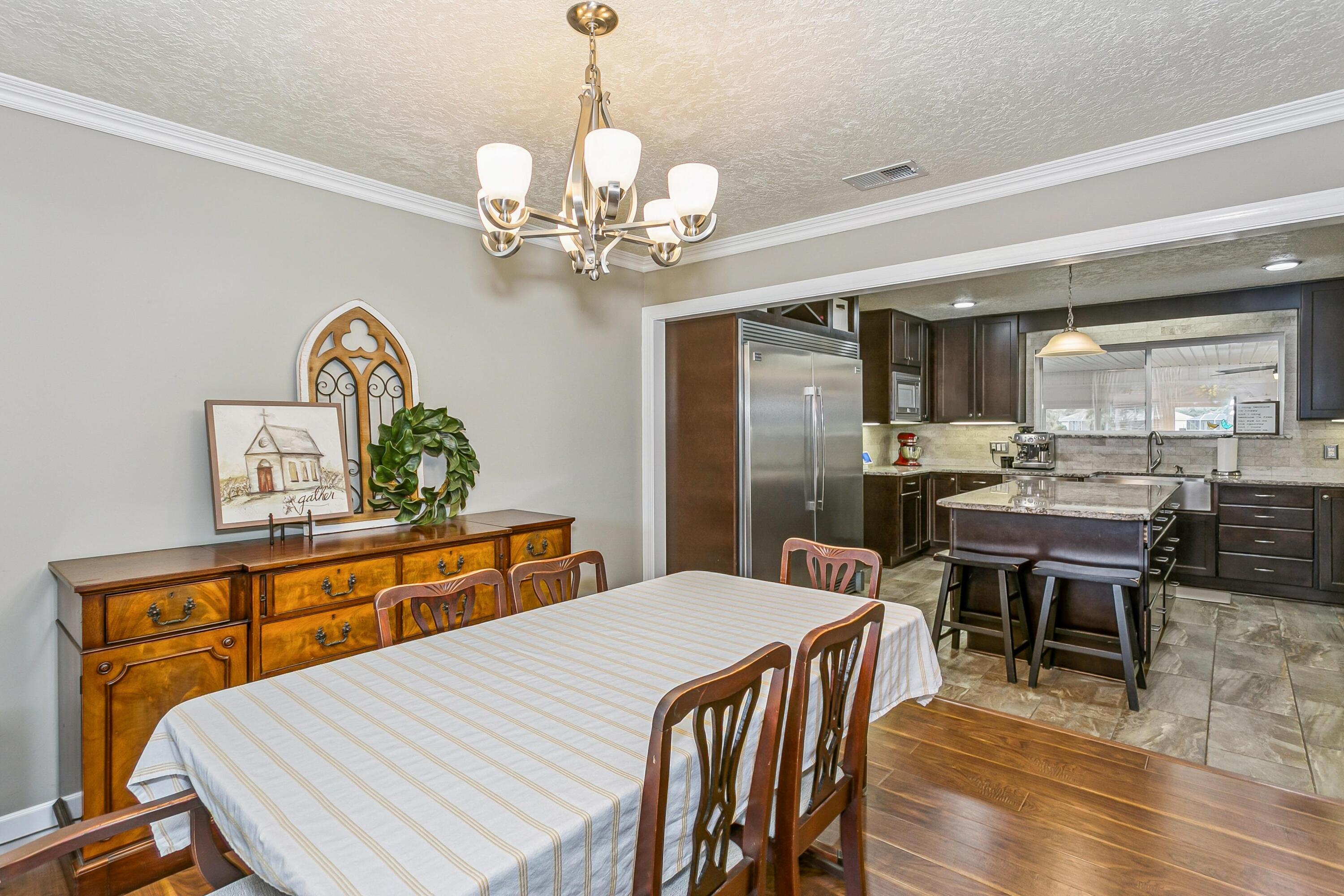 76 Country Club Road Shalimar, FL 32579 - Photo 5 of 47 a view of a dining room with furniture a chandelier and wooden floor