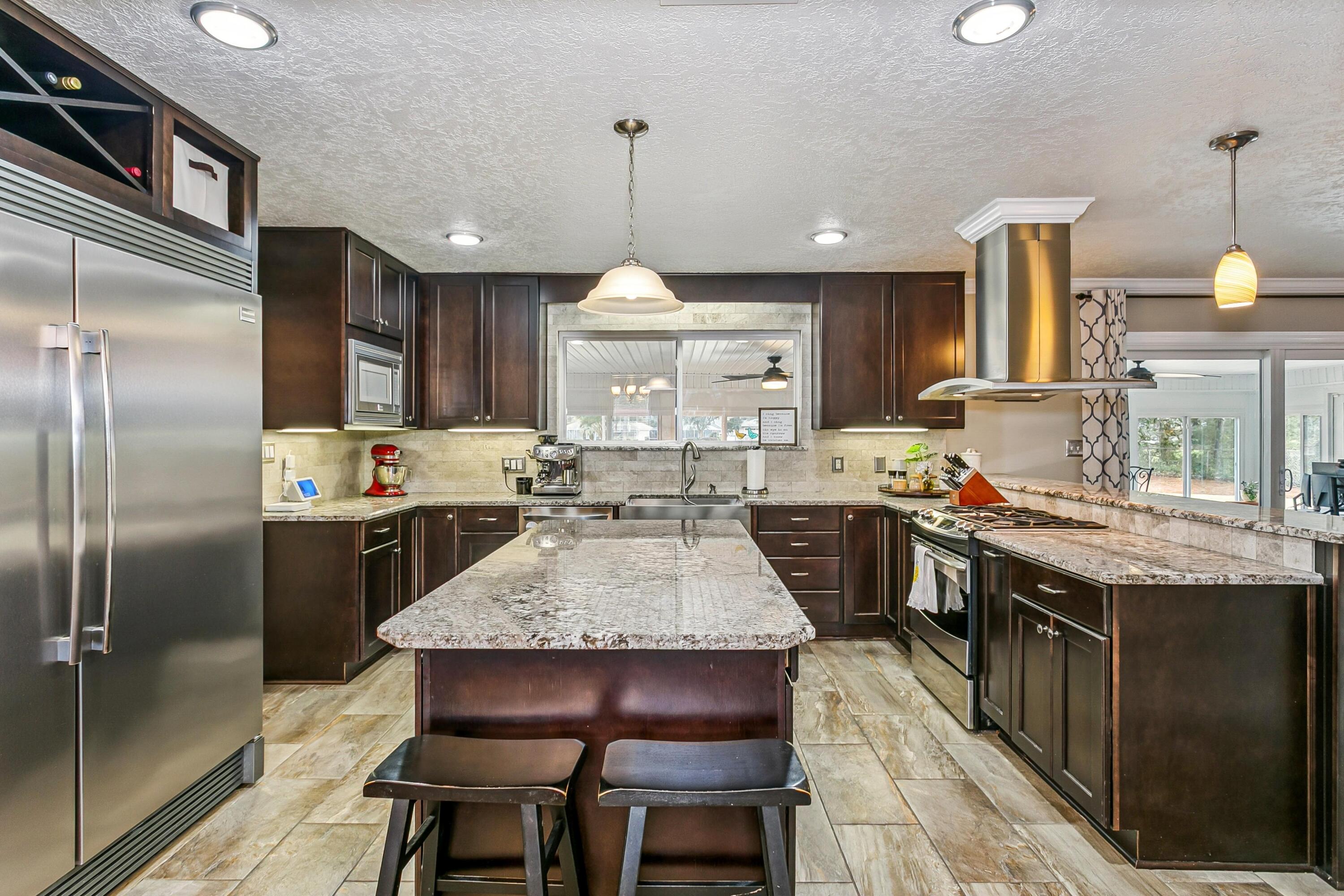 76 Country Club Road Shalimar, FL 32579 - Photo 6 of 47 a kitchen with granite countertop a center island a sink stainless steel appliances and cabinets