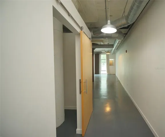 a view of a kitchen with a refrigerator and wooden floor