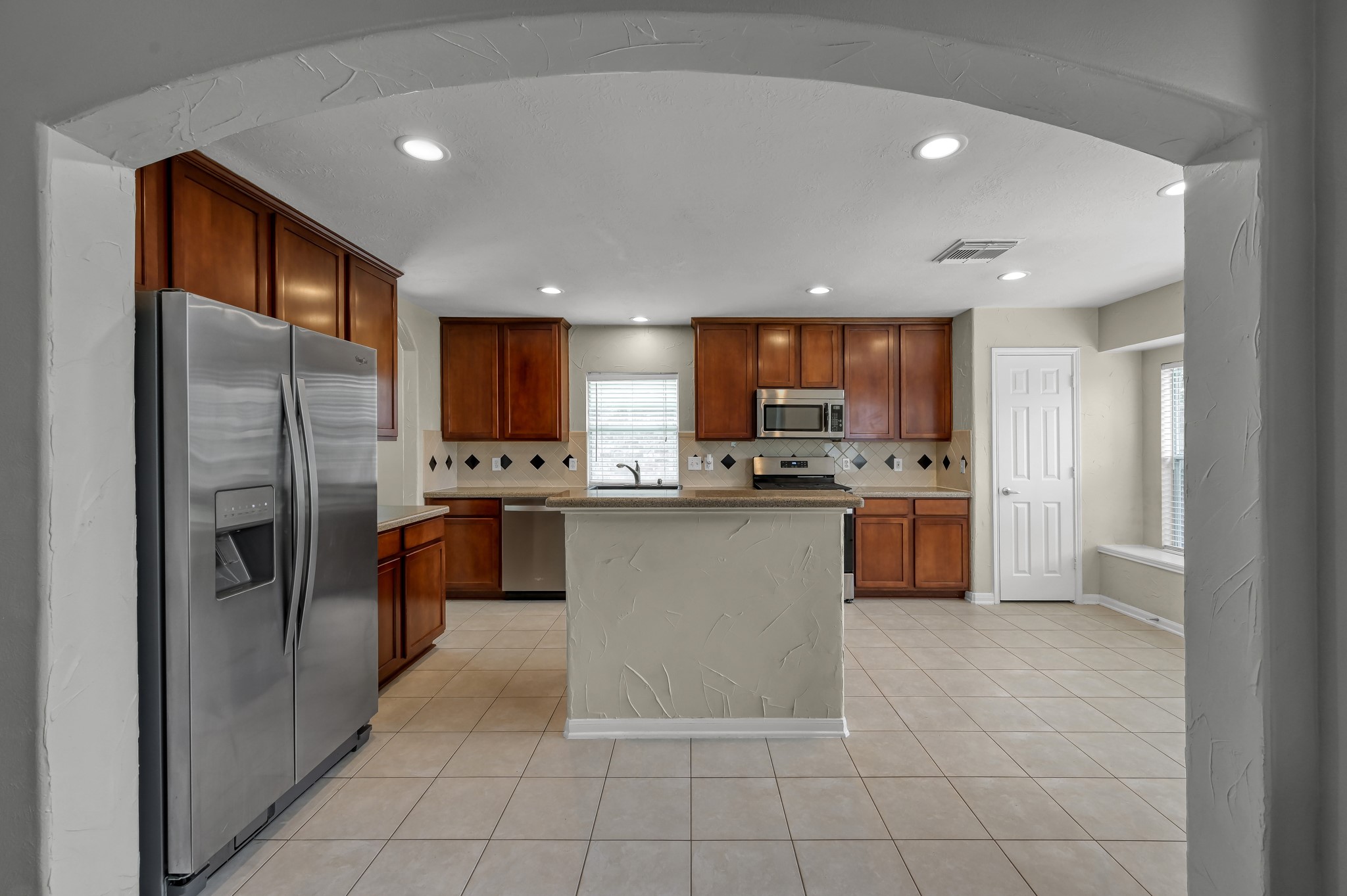 21331 Timber Pines Drive Spring, TX 77388 - Photo 7 of 22 Enter past another decorative arch way into your AMAZING island kitchen! Large windows in the breakfast nook, a window perched above the sink and recessed lighting all keep this space light and bright!