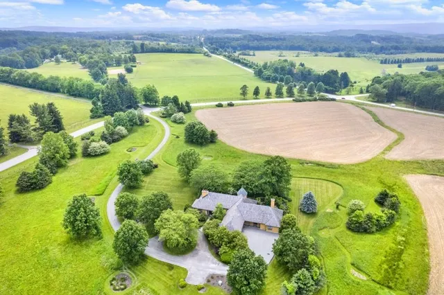 an aerial view of a residential houses with outdoor space and a lake view