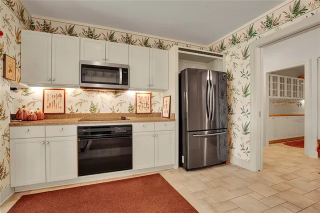 a kitchen with stainless steel appliances granite countertop a refrigerator microwave and stove top oven