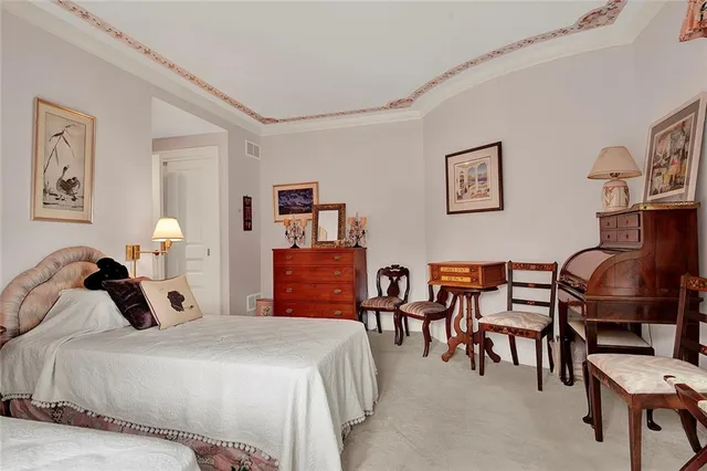 a bedroom with a bed and dresser with chair