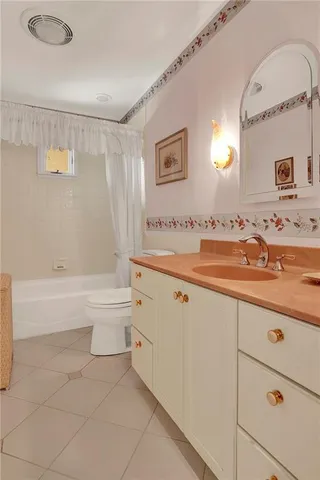 a bath room with a sink a toilet and a mirror