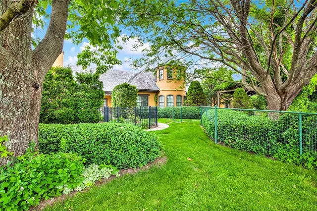 a view of a house with a big yard and large trees