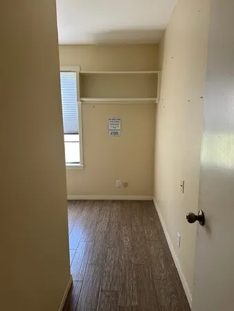a view of a room with wooden floor and a window