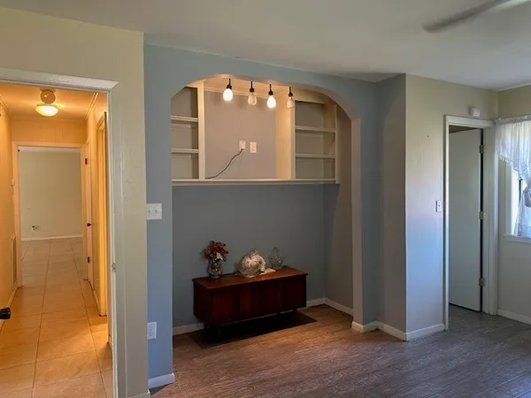a view of a workspace with wooden floor and windows
