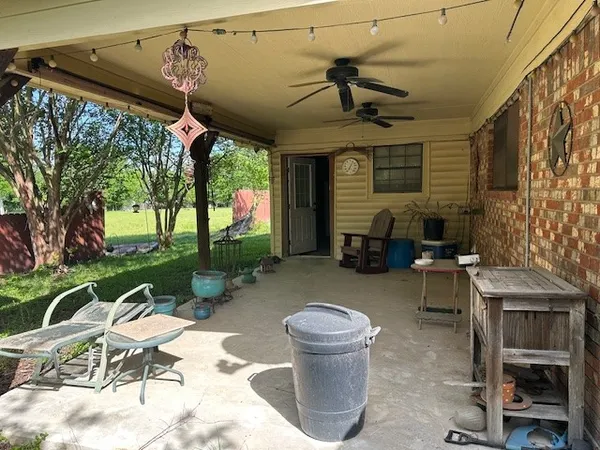 a view of a porch with furniture and a yard