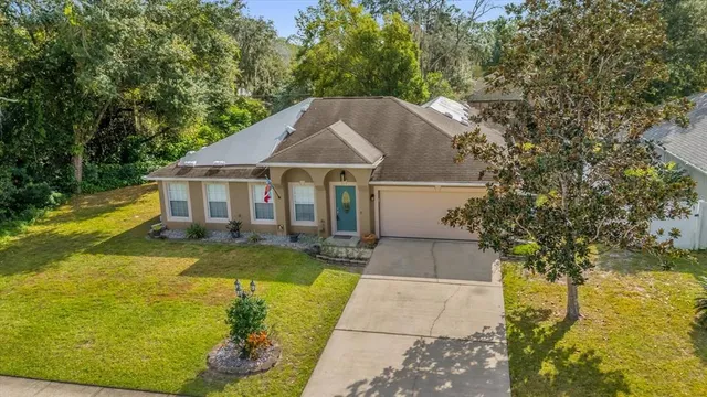 a view of a house with swimming pool next to a yard
