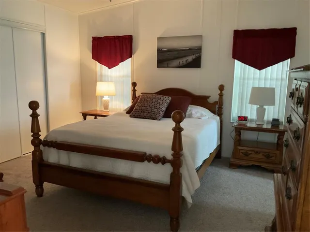 a bedroom with a bed a mirror and dresser