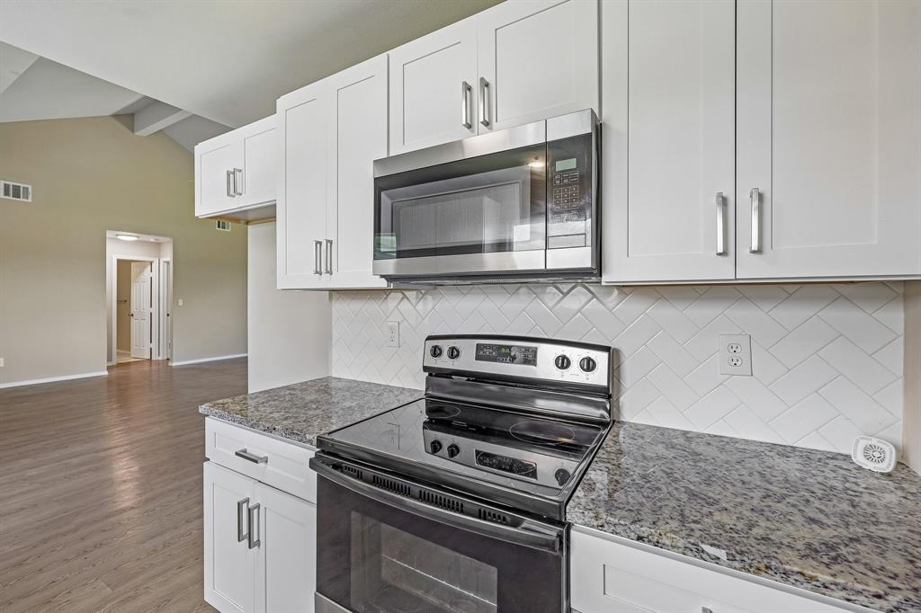 433 Whitney Court Rio Vista, TX 76093 - Photo 13 of 27 a kitchen with granite countertop cabinets stainless steel appliances and a wooden floor