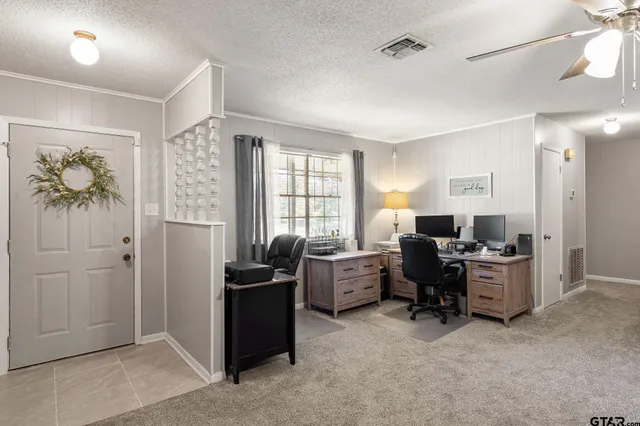 a view of a livingroom with workspace and a window