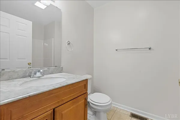 a bathroom with a granite countertop sink a toilet and a mirror