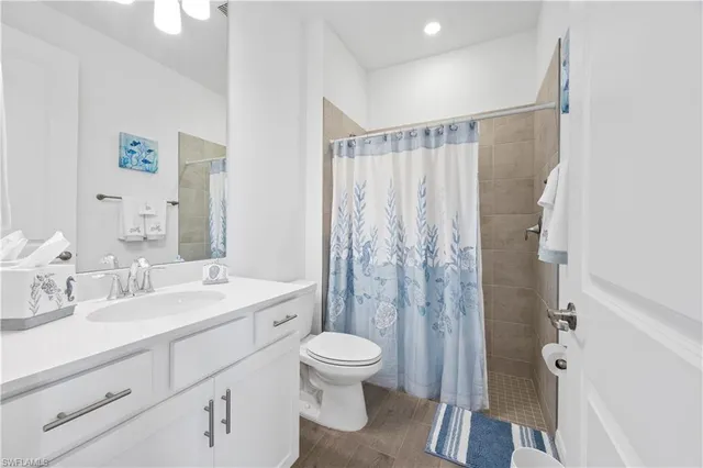 a bathroom with a double vanity sink toilet mirror and shower