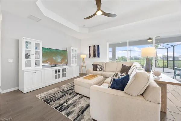 a living room with furniture a flat screen tv and a chandelier
