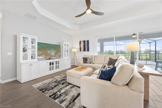 a living room with furniture a flat screen tv and a chandelier