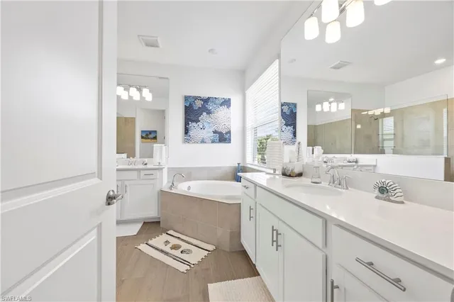 a spacious bathroom with a sink a large mirror and a shower