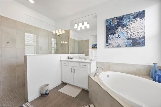 a bathroom with a bathtub a double vanity sink and mirror