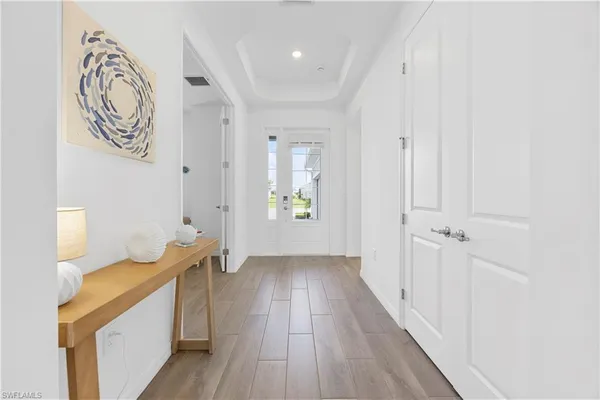 a view of a hallway with wooden floor and a bathroom