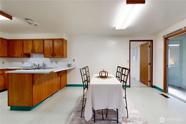 a kitchen with stainless steel appliances granite countertop a sink window and chairs