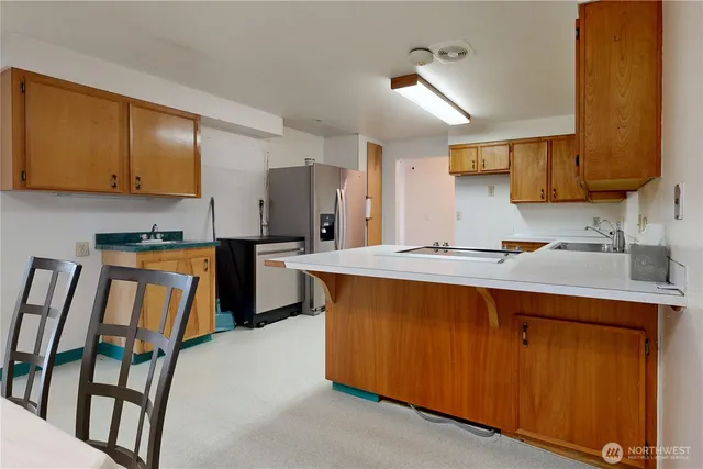 a kitchen with granite countertop a sink stainless steel appliances and cabinets