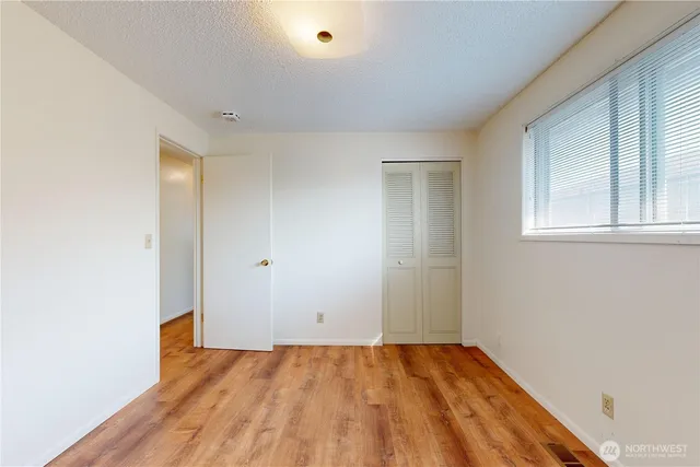 a view of an empty room and window and wooden floor