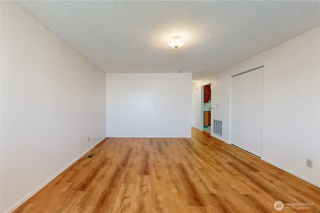 a view of empty room with wooden floor