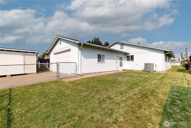 a view of a white house with a yard and garage