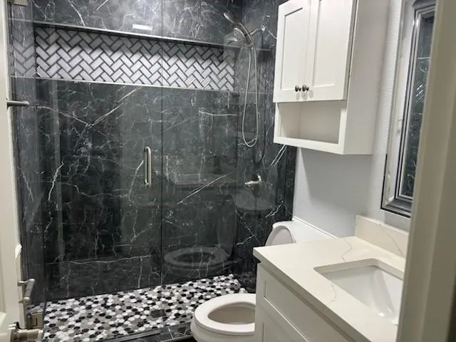 a bathroom with a sink toilet and shower