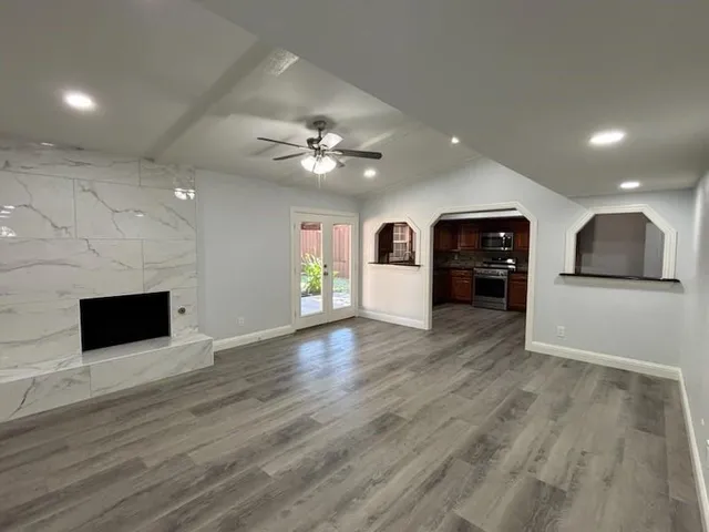 a view of a big room with wooden floor and windows