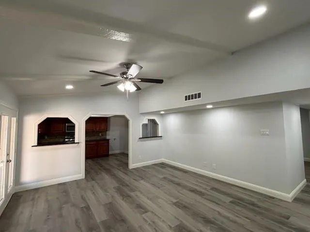 wooden floor in an empty room with a kitchen