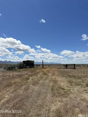 a view of a dry yard with wooden fence