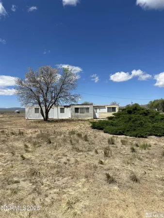 a vase of flowers sitting on a sidewalk
