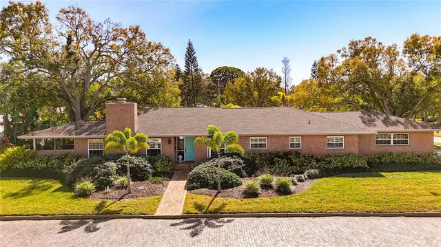 an aerial view of a house with a yard and large trees